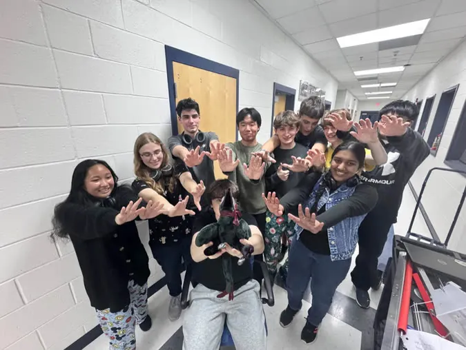 Raptoria members making claw hands in a hallway